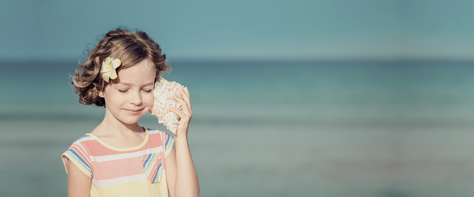 girl listening to a shell having fun